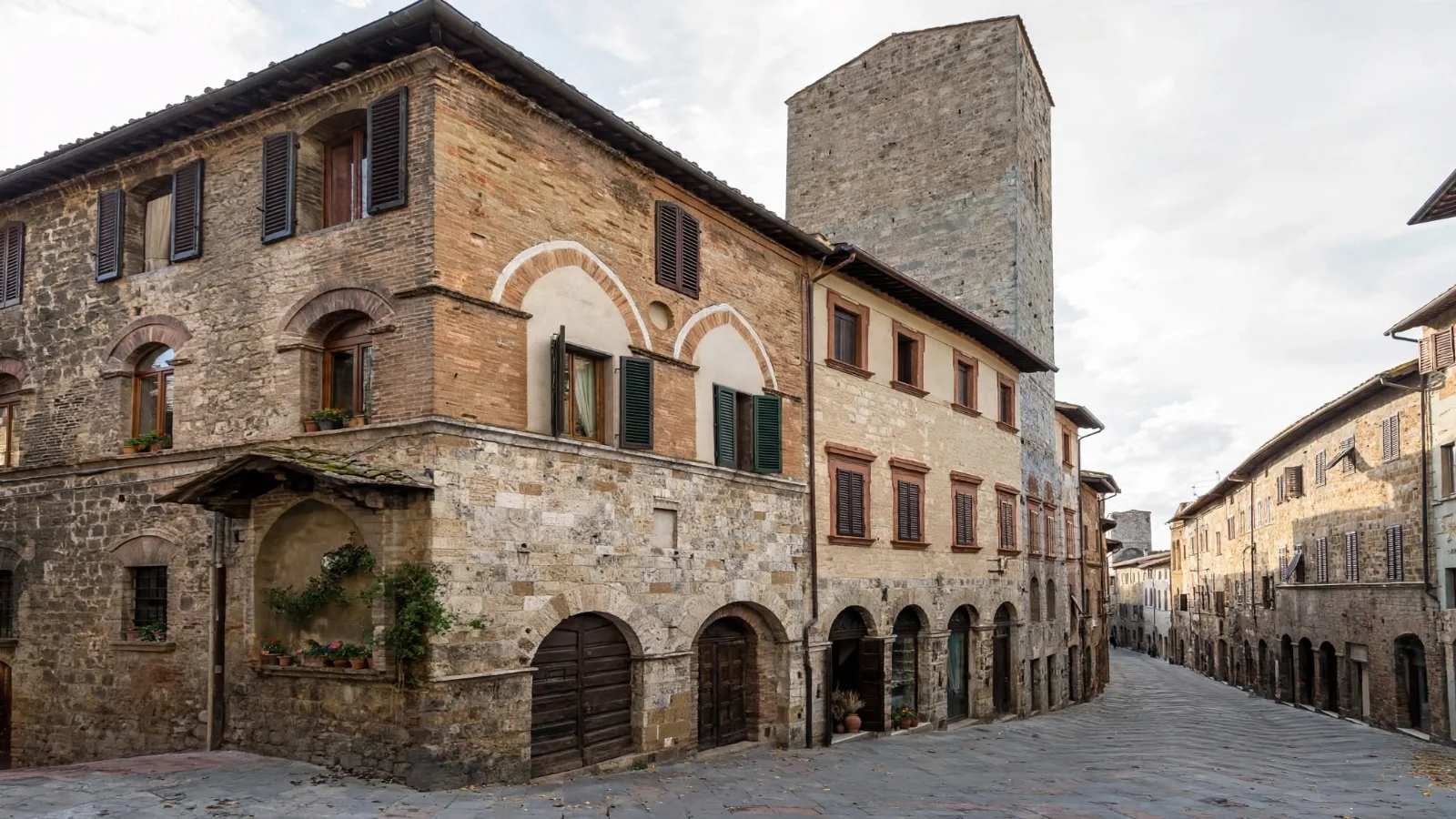 Exterior of Torre and Casa Campatelli on Via San Giovanni in San Gimignano showing its medieval tower and white blind arches