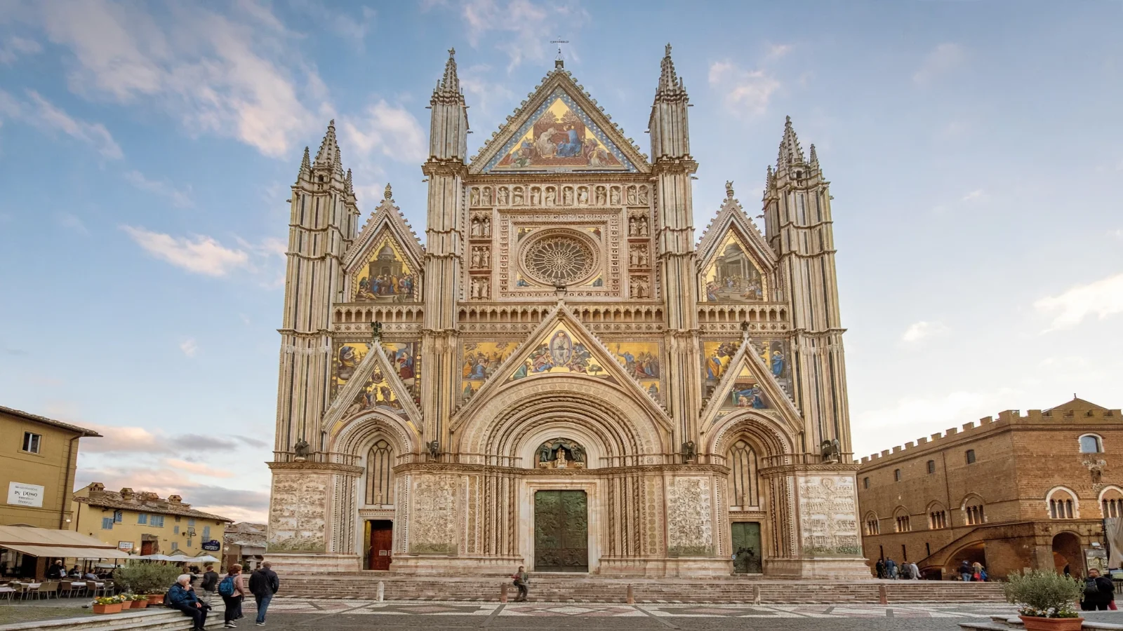 Orvieto Cathedral mosaic facade and striped stone walls facing Piazza del Duomo