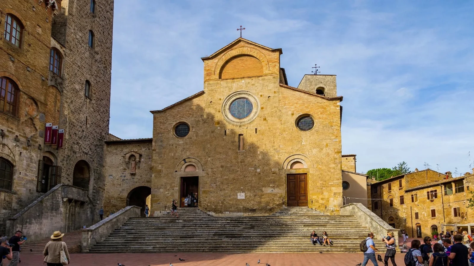 Facade of the Duomo of San Gimignano rising above the broad flight of stone steps on Piazza del Duomo