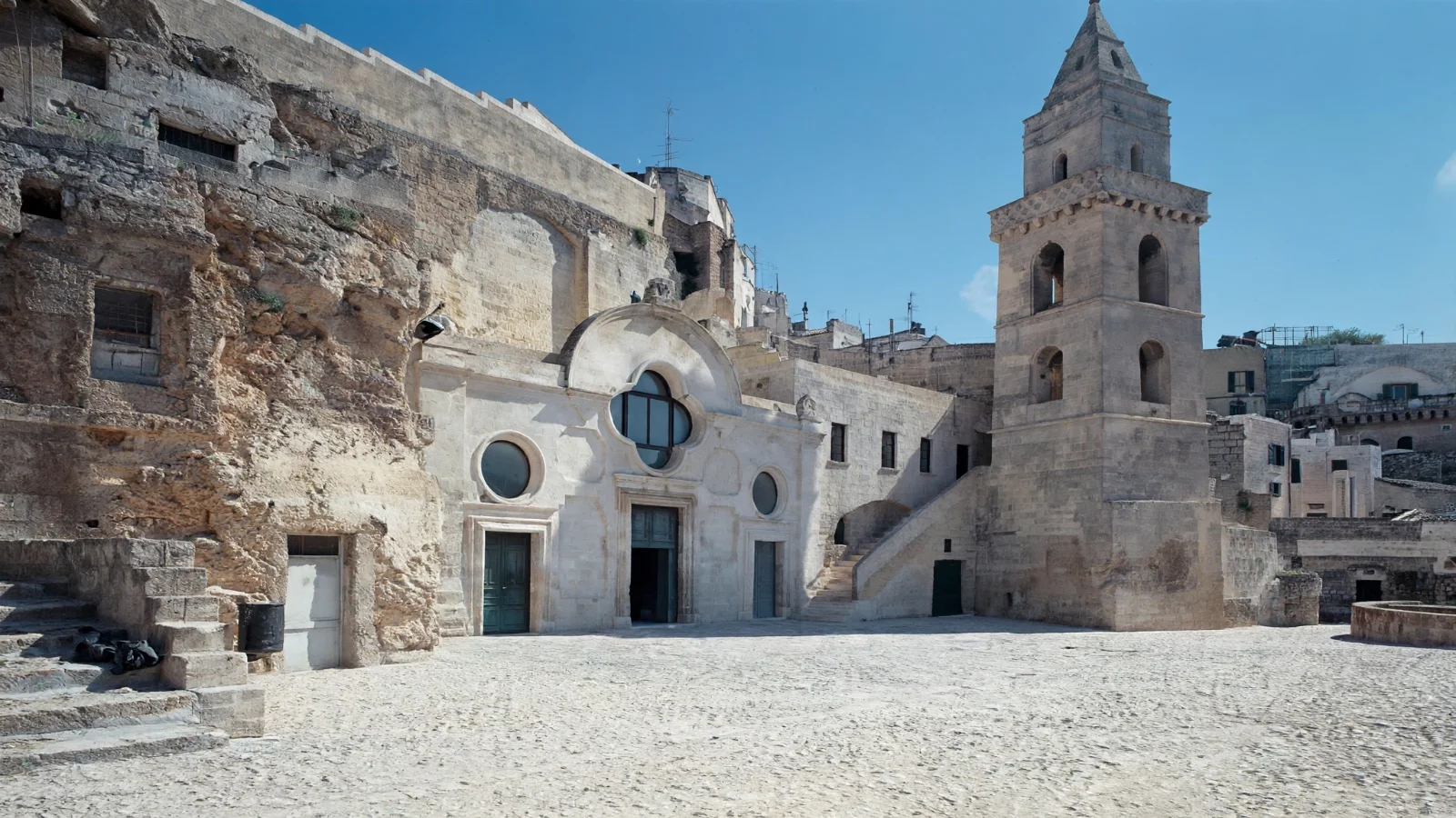 Stone facade and level forecourt of the rock-cut church of San Pietro Barisano in Matera